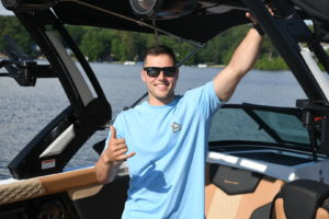 Ben gives the camera a thumbs up from the helm of the boat