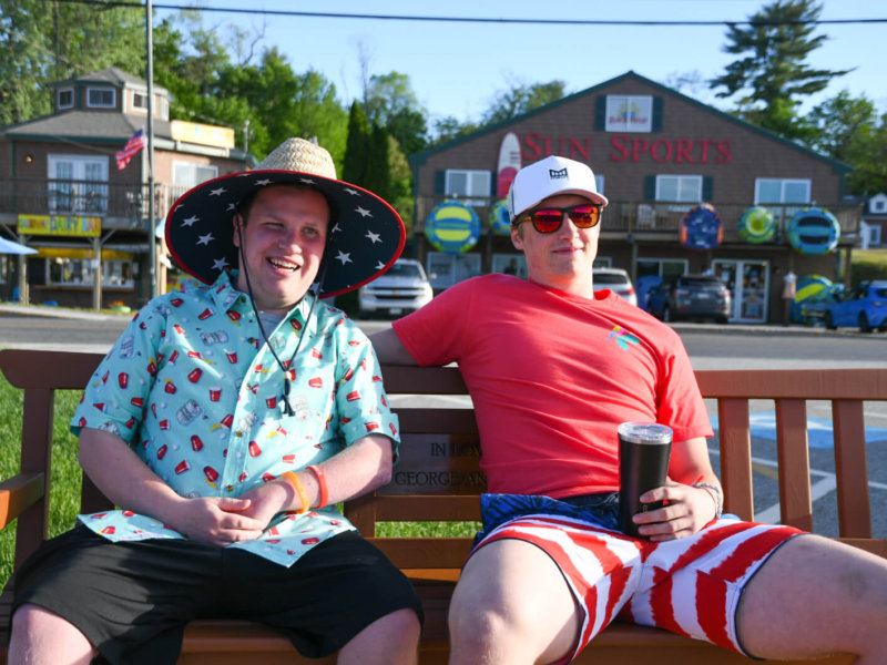 Two of our friends sitting down on a bench outside sunsports soaking up the sunshine